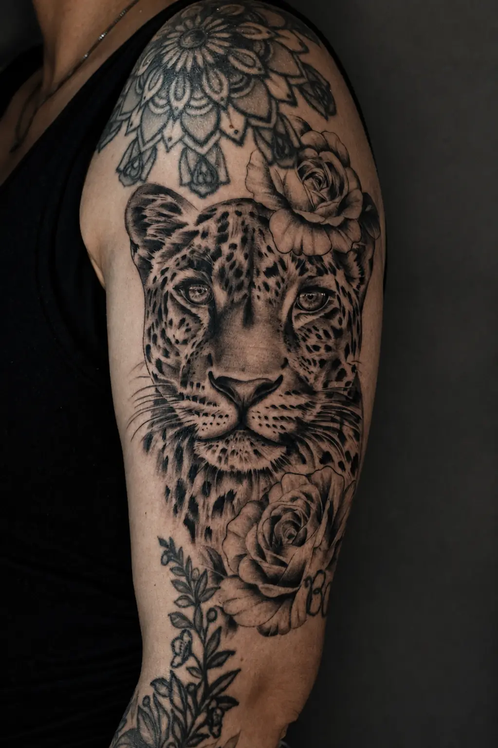 Realistisches Leoparden-Tattoo mit Rosen am Oberarm