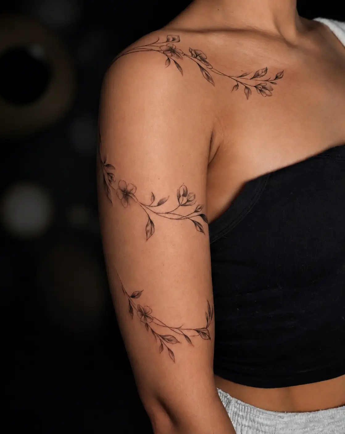 Florales Fine-Line-Tattoo über Schulter und Arm
