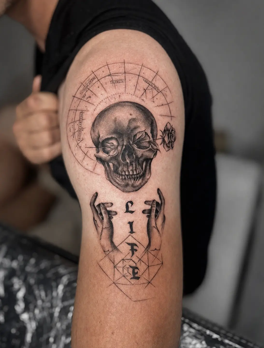Totenkopf mit Rose und grafischen Details am Oberarm